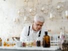 A senior male scientist working with aromatic substances in an indoor laboratory setting.