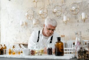 A senior male scientist working with aromatic substances in an indoor laboratory setting.