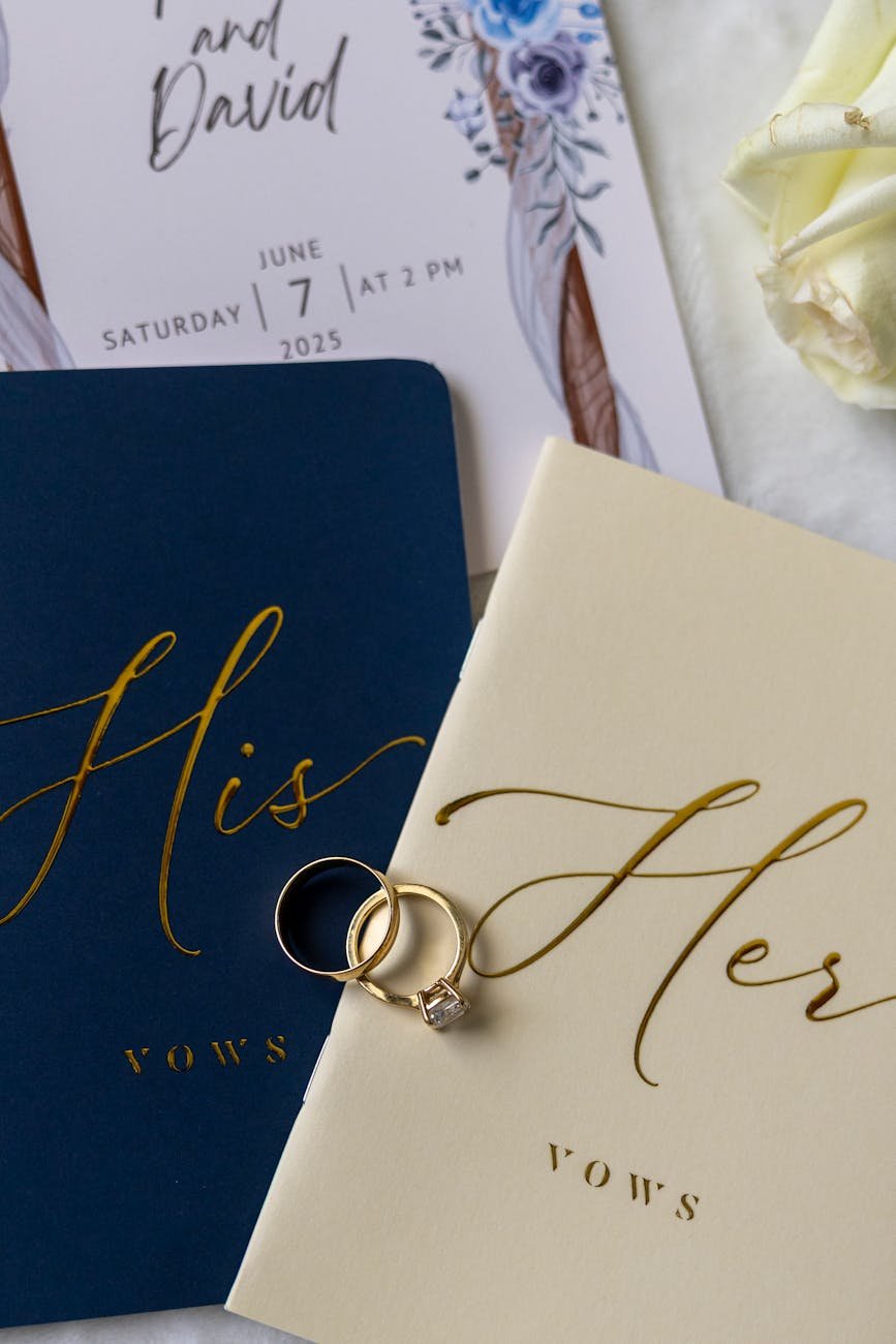 Elegant 'His and Her' vow books with wedding rings and invitation card, perfect for marriage photography.